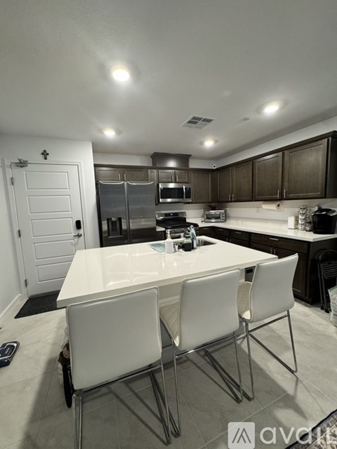 A kitchen with a white table and chairs.