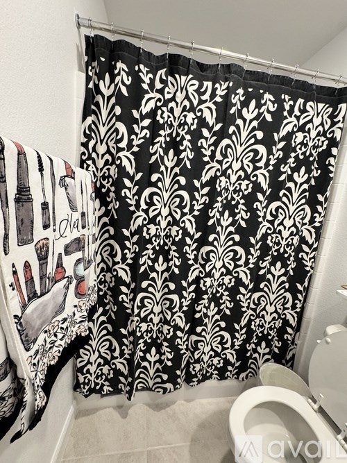 A black and white shower curtain with a damask pattern.
