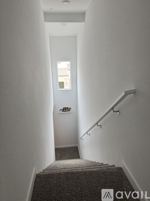 A stairway with a carpeted runner and a metal handrail.