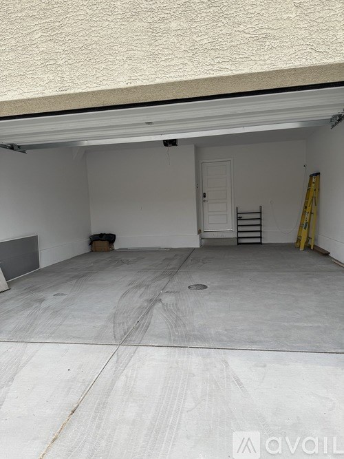 A garage with a white door and a concrete floor.