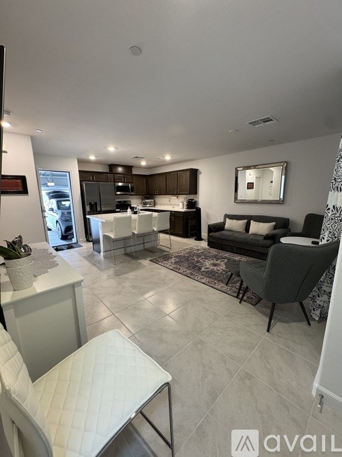 A modern kitchen with a dining area and a living room.
