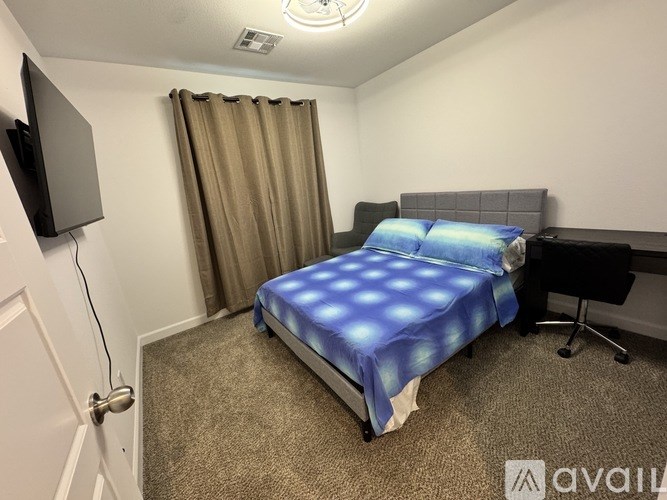 A bedroom with a bed, desk, and chair.