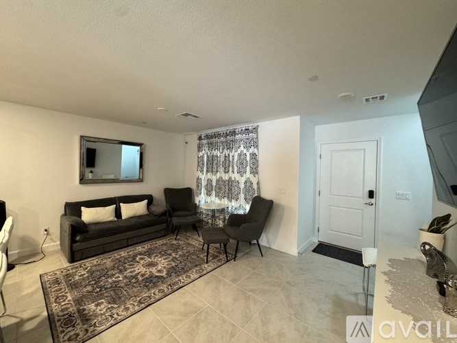 A living room with a couch, chair, and rug.