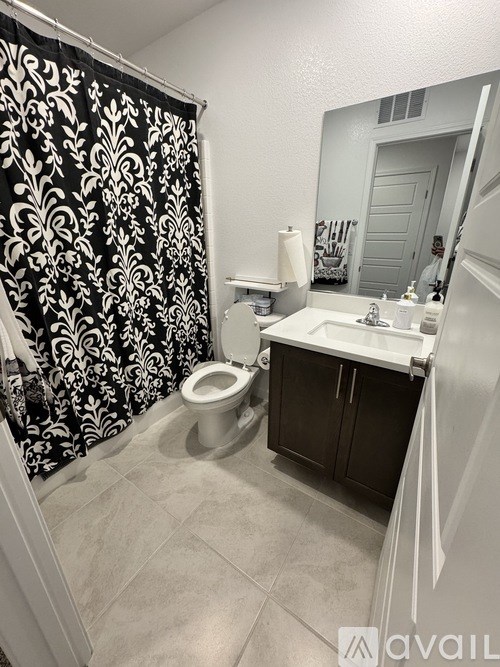 A bathroom with a black and white shower curtain.