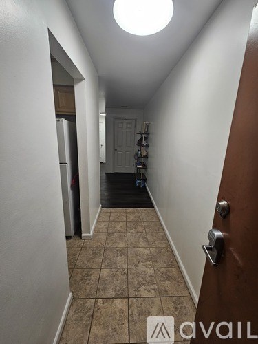 A hallway with a tiled floor and a door on the right.