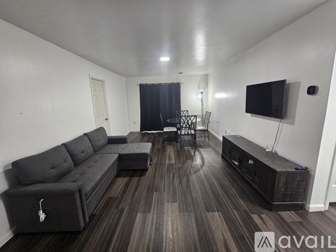 A living room with a grey sofa and wooden flooring.