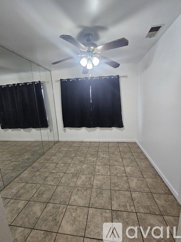 A room with a ceiling fan and tiled flooring.