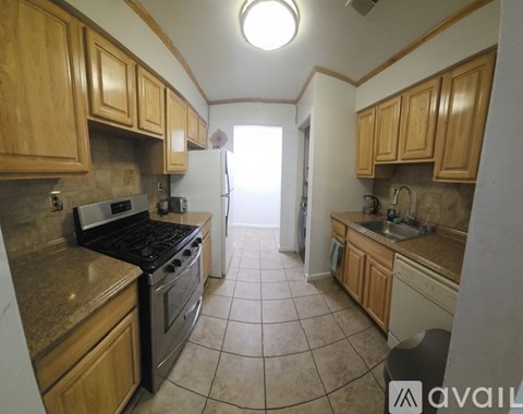 A kitchen with wooden cabinets and a black stove top oven.