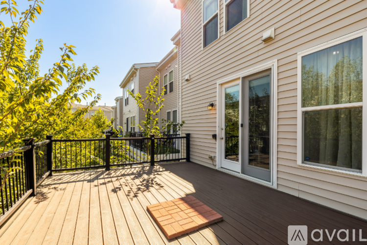 A wooden deck with a black railing and a small table in the middle.