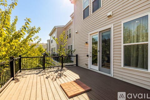 A wooden deck with a black railing and a small table in the middle.