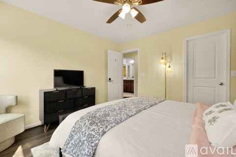 A bedroom with a bed, dresser, and television.