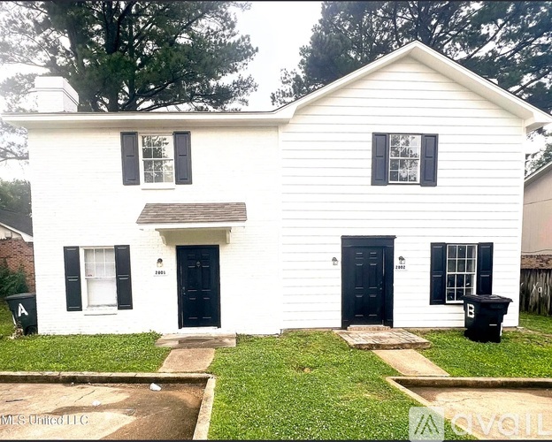 A white house with a black door and windows.