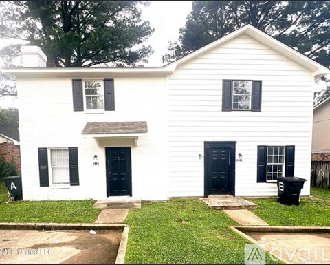 A white house with a black door and windows.