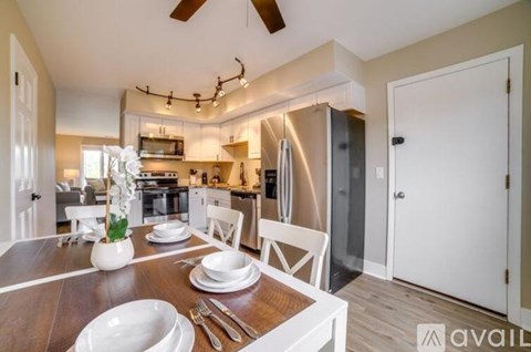 A modern kitchen with a dining table set for two.
