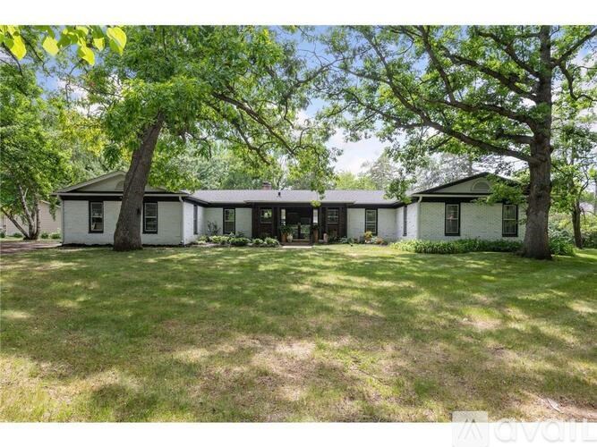 A white house with a tree in front of it.