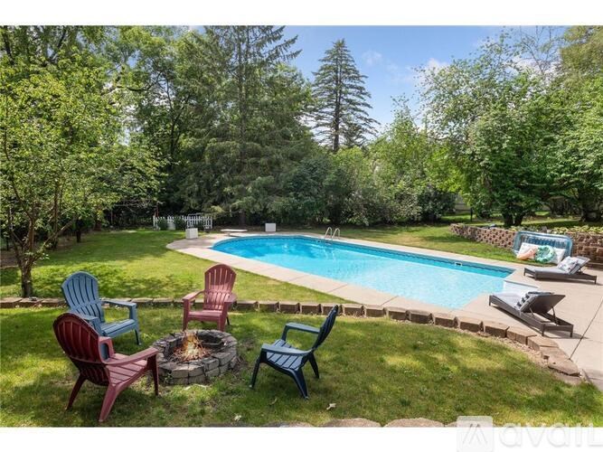 A backyard with a pool and chairs.