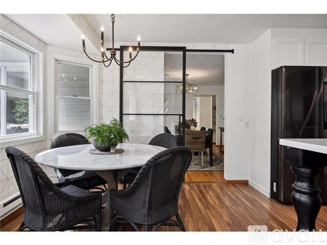 A dining room with a white table and black chairs.