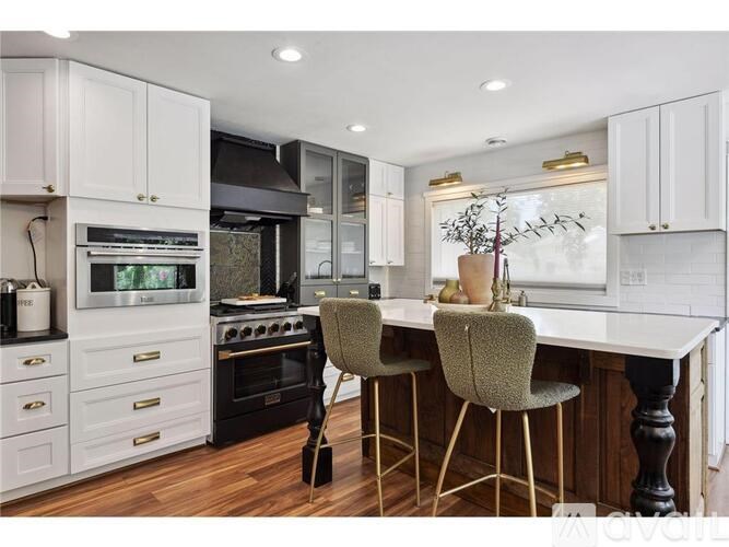 A kitchen with white cabinets and a black stove top oven.
