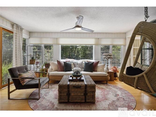 A living room with a sofa, armchair, and a hanging chair.