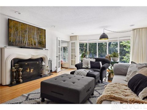 A living room with a fireplace and a large painting on the wall.