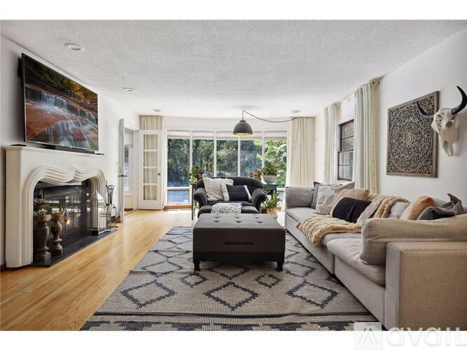 A living room with a fireplace and a large painting on the wall.