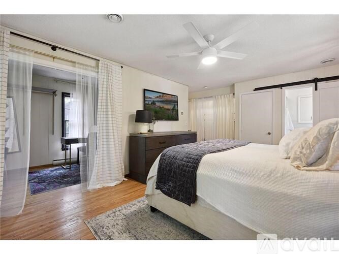 A bedroom with a large bed and a ceiling fan.