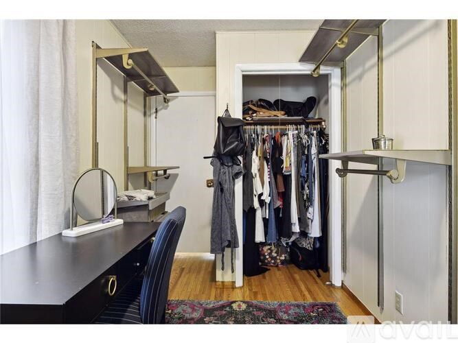 A room with a black dresser and a mirror with a gold frame.