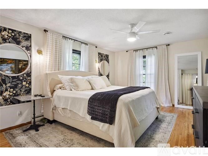 A bedroom with a large bed and a ceiling fan.