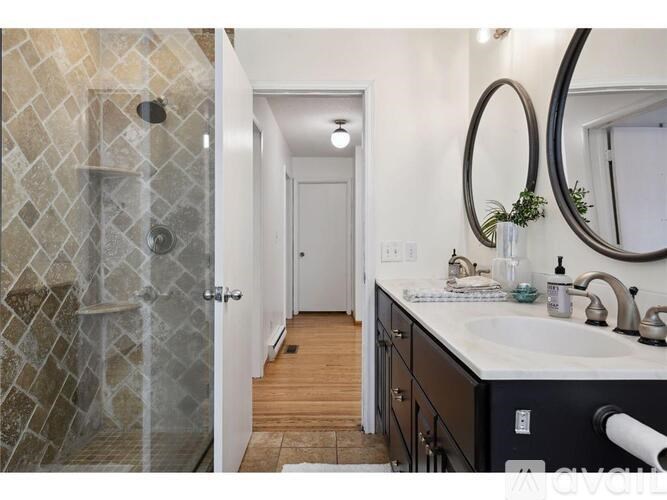 A bathroom with a walk-in shower and double sink vanity.