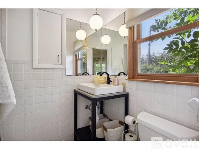 A bathroom with a white sink and a window.