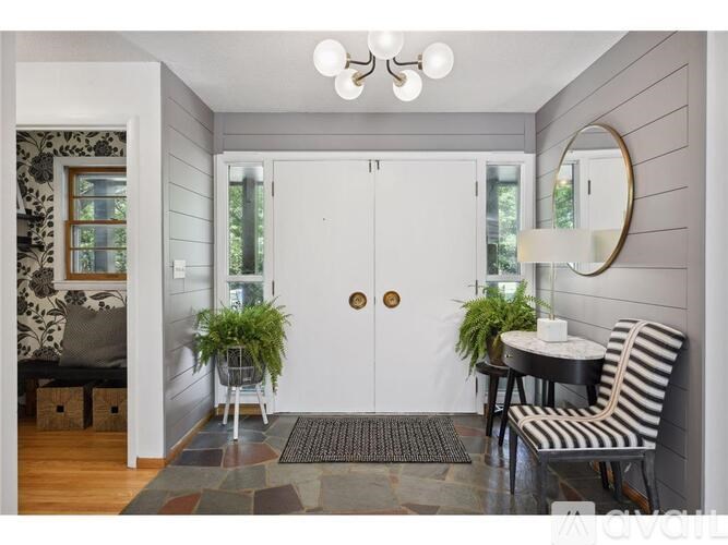 A small room with a table and chairs and a mirror on the wall.