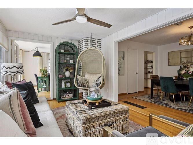A living room with a white ceiling fan and a large mirror on a stand.
