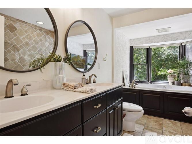 A bathroom with a white sink and black cabinets.