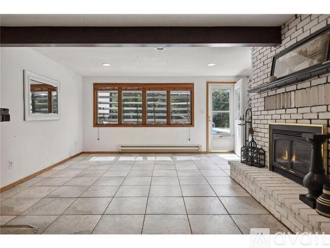 A living room with a fireplace and a large window.