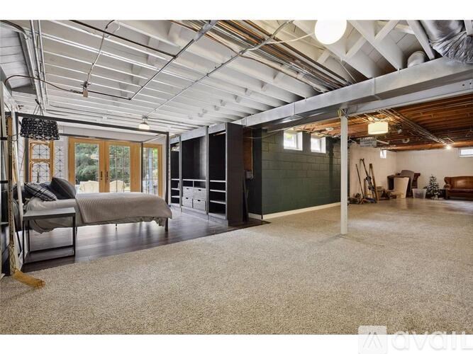 A large, empty room with a bed, a desk, and a chair.