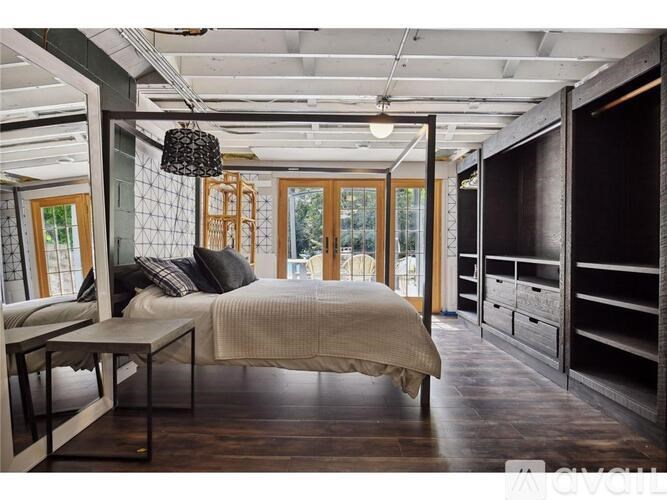 A bedroom with a bed, nightstands, and a window.