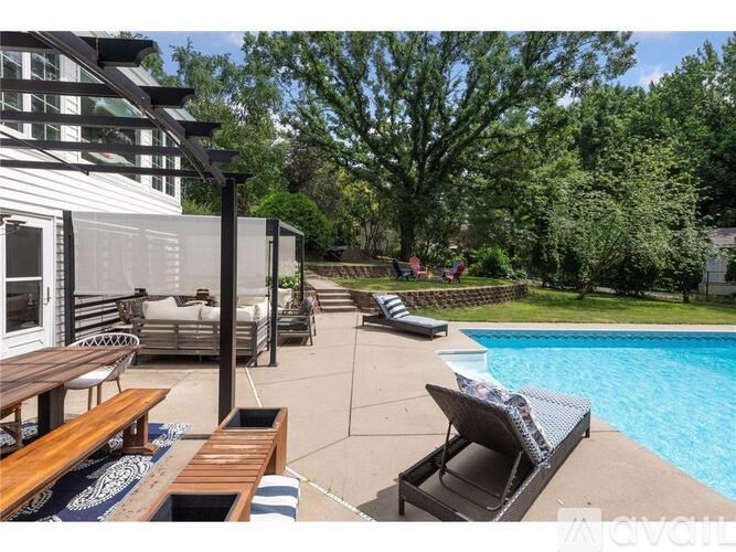 A poolside patio area with a table and chairs.