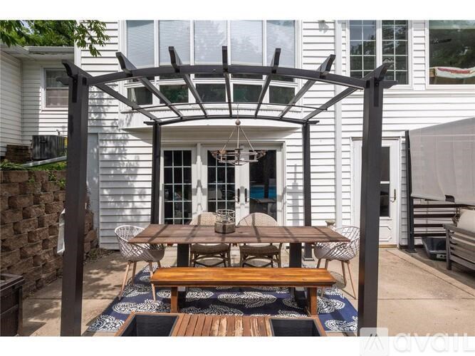 A patio with a table and chairs under a pergola.
