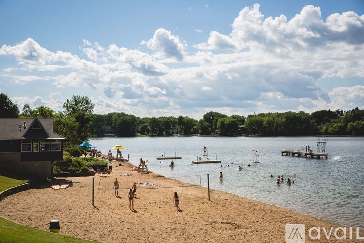 A beach scene with people swimming and a building in the background.