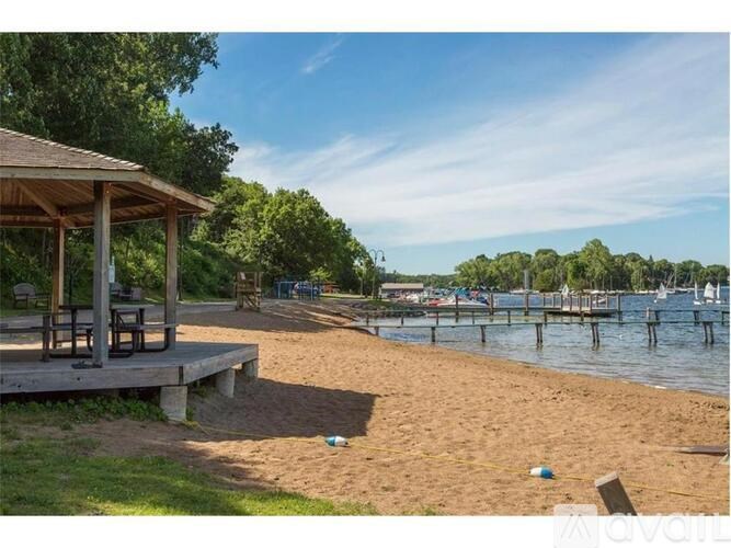 A beach scene with a gazebo and boats in the distance.