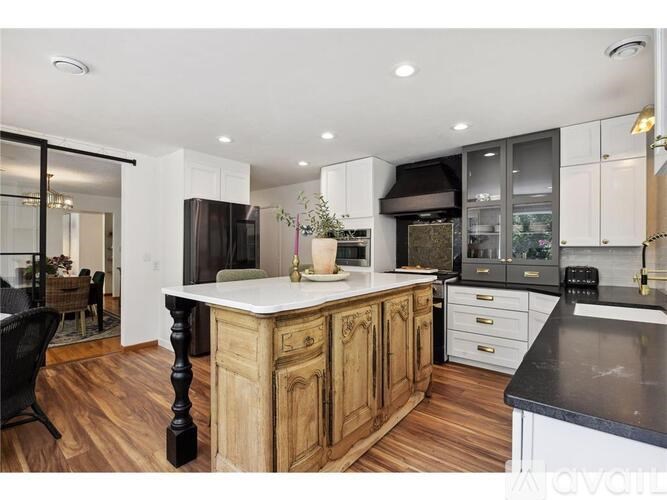 A kitchen with wooden cabinets and black countertops.