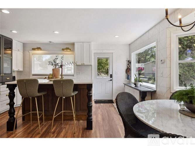 A kitchen with a table and chairs in front of a window.