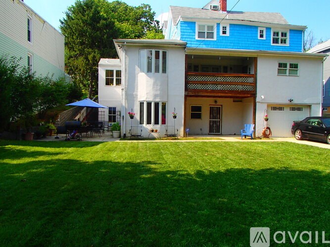 A two-story house with a blue roof and white walls.