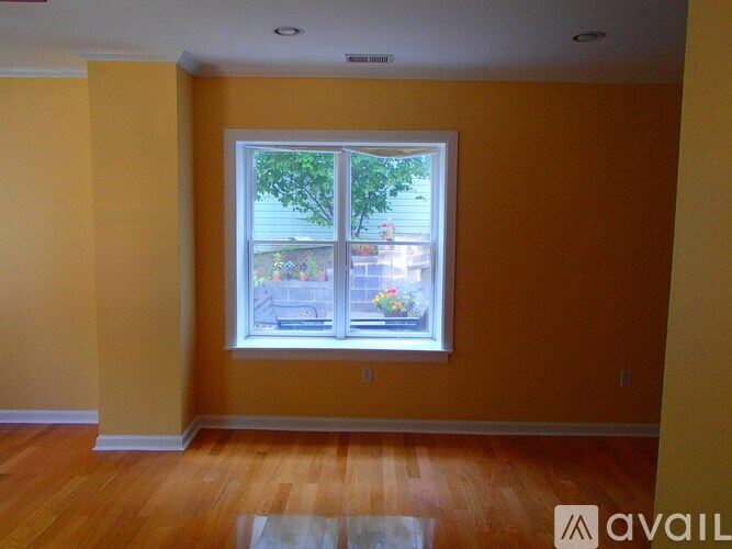 A room with a window and wooden floors.