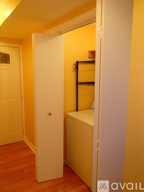 A white door is open to a room with a shelf.