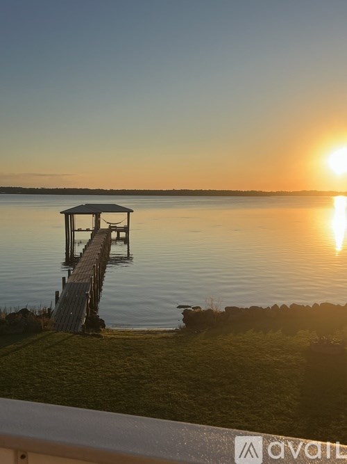 A sunset view with a dock in the foreground.