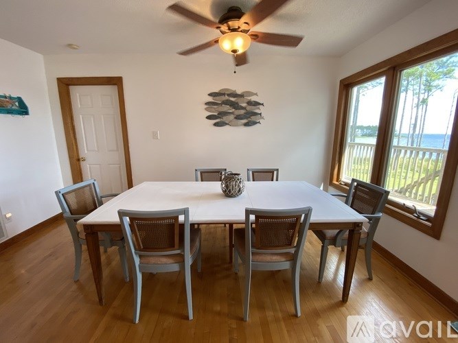 A dining room with a white table and chairs.
