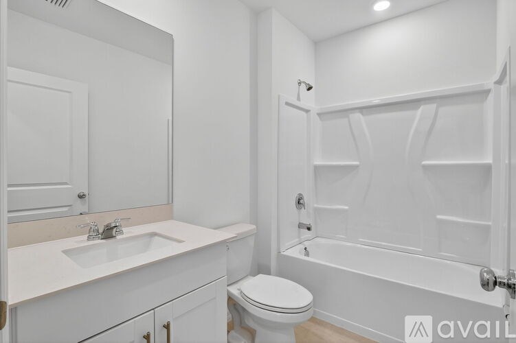 A white bathroom with a toilet, sink, and bathtub.
