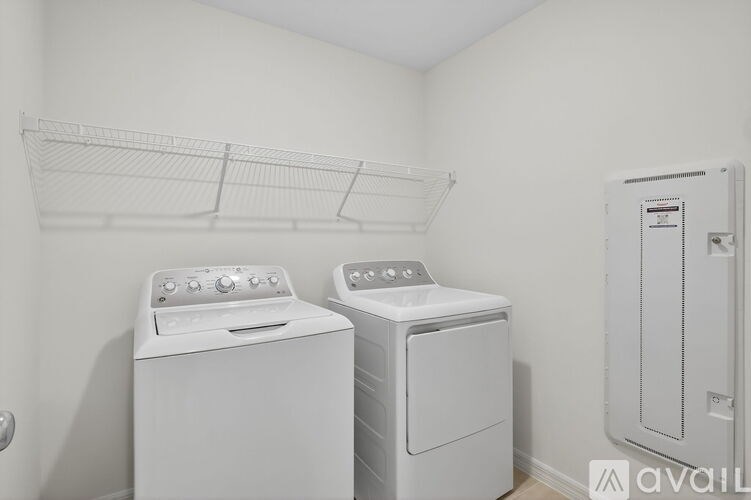 A laundry room with a washer and dryer and a clothes drying rack.
