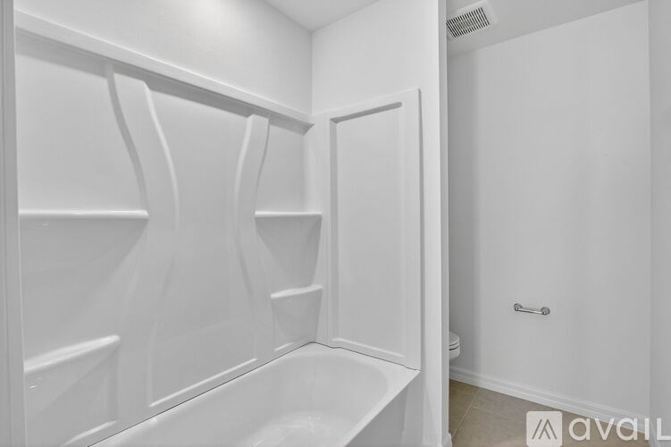 A white bathroom with a tub and a toilet.